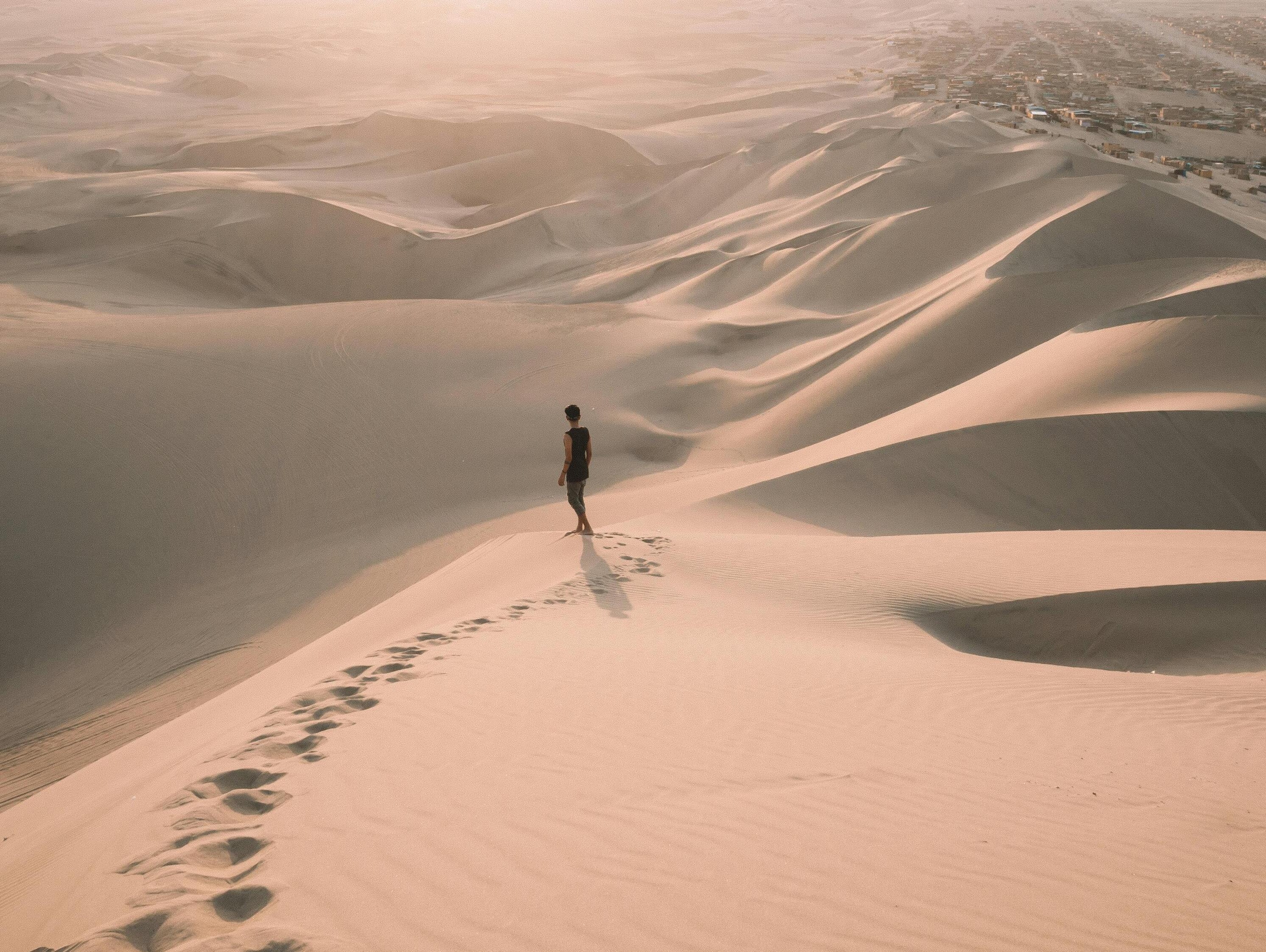 Person walking on desert dunes